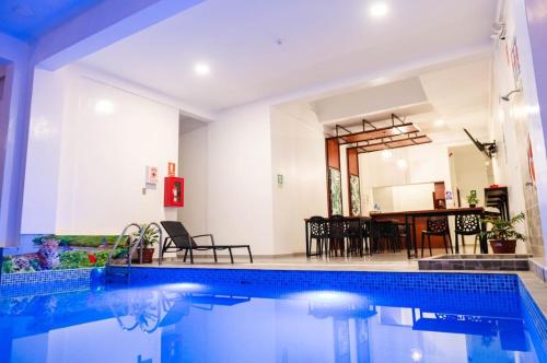 a house with a swimming pool and a dining room at HOTEL SAN JUAN, Tarapoto in Tarapoto
