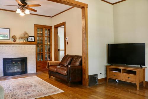 a living room with a television and a leather chair at Historic Home with Outdoor Hot Tub Near Downtown in Public Transportation Hub in Chicago