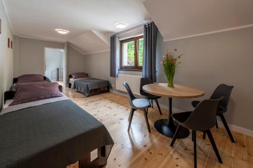een slaapkamer met een bed en een tafel en stoelen bij Górskie Klimaty in Kletno