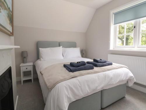 a bedroom with a bed with two towels on it at 2 Golf Links Cottages in Northwich