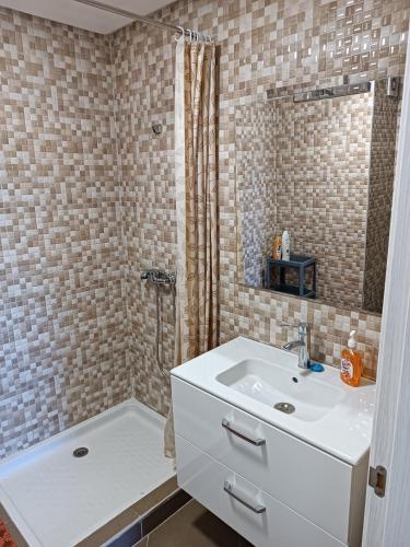 a bathroom with a white sink and a shower at Appartement avec piscine à Mohammedia Plage à 5min in Mohammedia