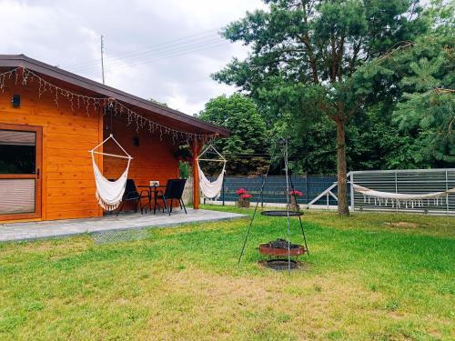 a house with a hammock in the yard at Agroturystyka Rancho Łęg in Kruszyna