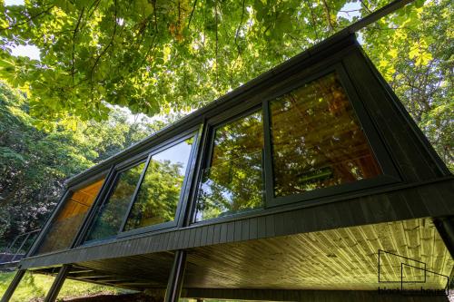 a house in the woods with large windows at Blackbox House Noszvaj in Noszvaj