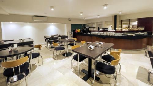 a restaurant with tables and chairs and a counter at Hotel HR Plaza Luxor in Buenos Aires