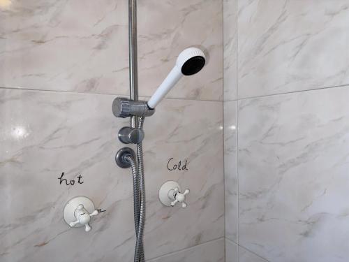 y baño con ducha con cabezal de ducha. en Cozy room near Metro en Lisboa