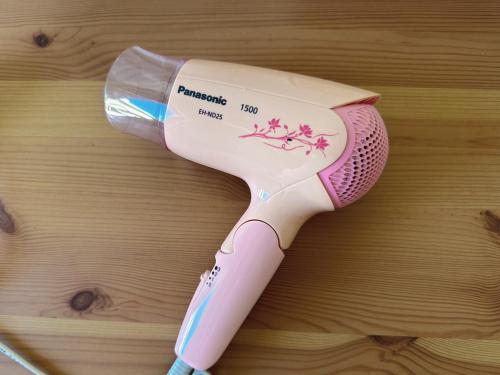 a pink electric toothbrush sitting on a wooden table at Cozy Room near Metro & Airport in Lisbon