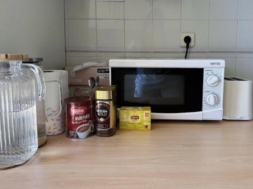 a microwave sitting on top of a kitchen counter at Cozy Room near Metro & Airport in Lisbon