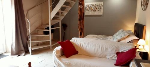 ein Wohnzimmer mit einem weißen Sofa und einer Wendeltreppe in der Unterkunft La Dame Blanche in Saint-Maurice-dʼIbie