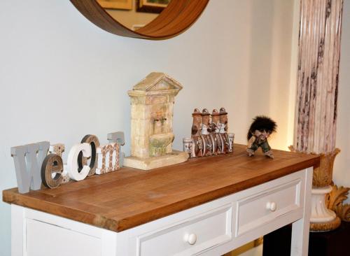 un comptoir en bois avec des figurines et un miroir dans l'établissement All That Sicily ORTIGIA, à Syracuse