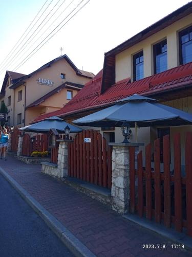 a fence with umbrellas in front of a building at Lusia in Wisła