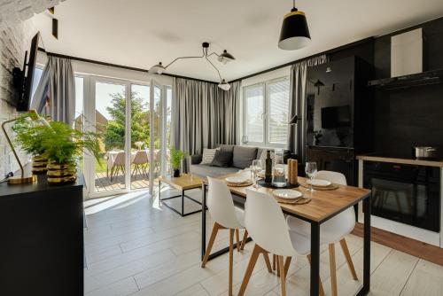 a dining room and living room with a table and chairs at Domek Zielony Zakątek in Słajszewo