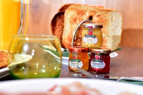 a table topped with jars of jam and bread at The Townhouse Aberfeldy - Rooms & Breakfast in Aberfeldy