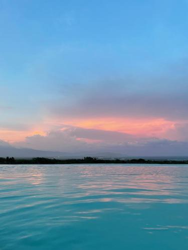 a large body of water with a sunset in the background at Altos de la Caobita in Barreras