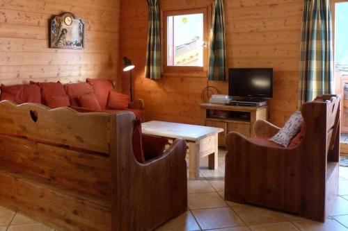 un salon avec un canapé et une télévision dans l'établissement Mercer - 3 bedroom apartment with stunning views, à Sainte-Foy-Tarentaise