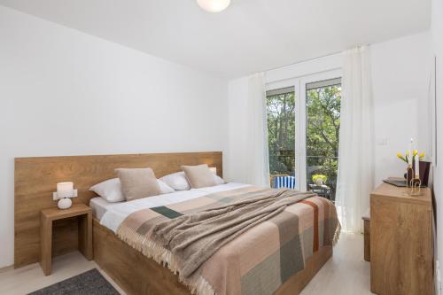 een slaapkamer met een groot bed en een raam bij Holiday Homes Oštro in Kraljevica