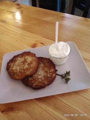 a plate with two donuts and a bowl of yogurt at Lusia in Wisła