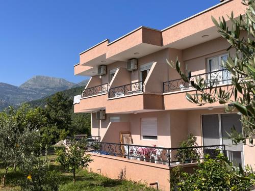 a building with balconies with mountains in the background at Guesthouse P&A in Budva