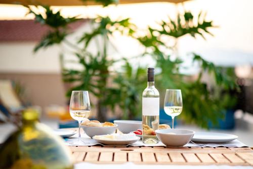 a table with a bottle of wine and two glasses at fragoseco loft! Elegance & Luxury in Chalkida