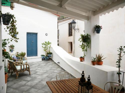 d'une terrasse avec une table et des chaises ainsi qu'une porte bleue. dans l'établissement Casa 3 Guesthouse and Artist Residence, à Polopos
