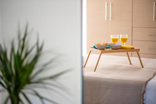 a table with two glasses of wine and a bowl of food at fragoseco loft! Elegance & Luxury in Chalkida