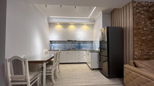 a kitchen with a table and a refrigerator at Apartment in Tbilisi City