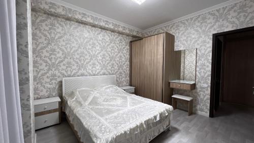 a bedroom with a bed and a wooden cabinet at Apartment in Tbilisi City
