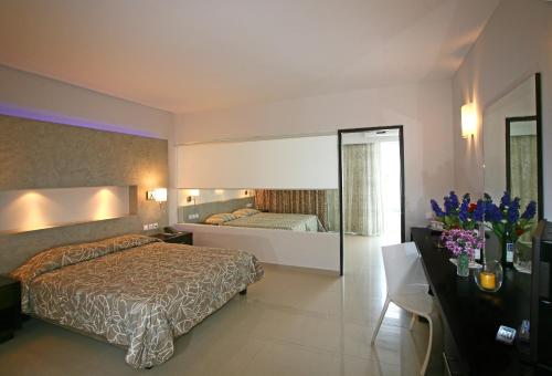 Habitación de hotel con cama y espejo en Sun Palace Hotel Resort & Spa, en Cos