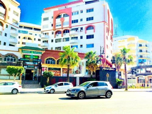 un aparcamiento con coches estacionados frente a los edificios en Complejo al andalous Apartamento, en Tánger