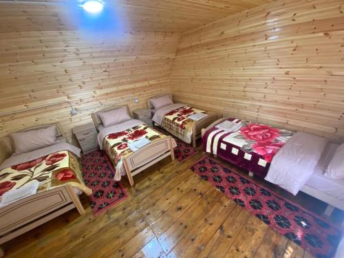 Habitación con 3 camas en una cabaña de madera en Hotel-Restorant Pepushaj en Shkodër