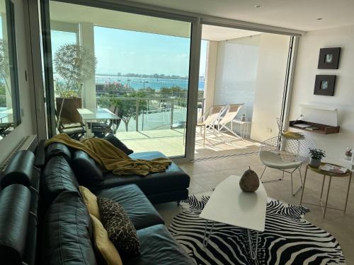 Una sala de estar con un sofá y vista al mar. en Capvespre, en Roses