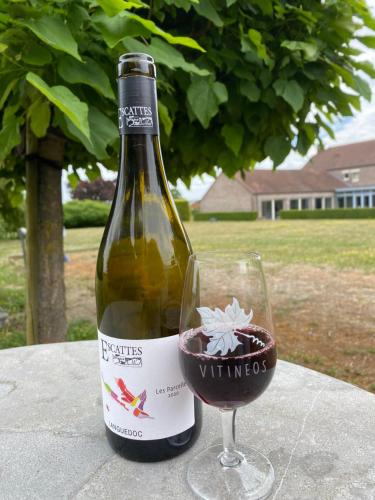a bottle of wine sitting next to a glass at La Clé des Champs in Jodoigne