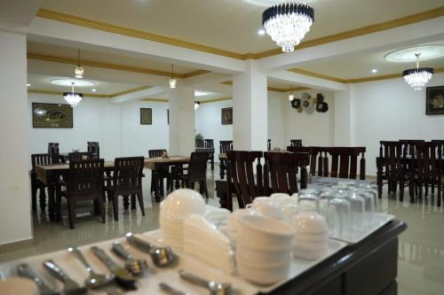 a dining room with chairs and a table with white dishes at THE JAMAWAR in Srinagar