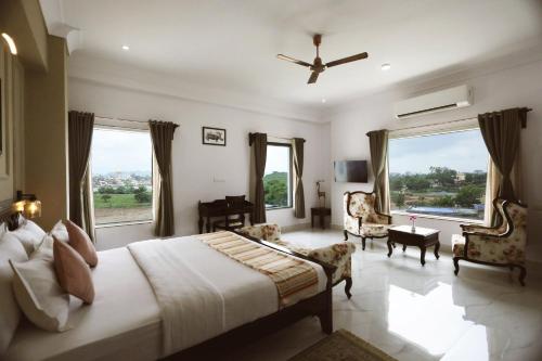 a bedroom with a large bed and large windows at Revaas Lake View Boutique Hotel in Udaipur