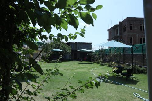 a yard with tables and umbrellas at THE JAMAWAR in Srinagar