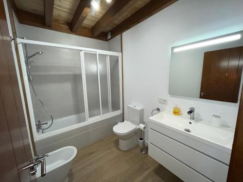 Un baño con inodoro, lavabo y ducha. en Villas Magnolia y Brezo, en Chiclana de la Frontera