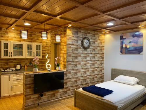 a kitchen with a large flat screen tv in a room at بيتي بلس للغرف الفندقية- مدخل مستقل in Riyadh Al Khabra