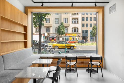 numa I Savi Rooms & Apartments في برلين: مطعم فيه طاولة وكراسي امام النافذة