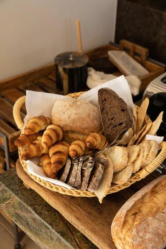 a basket of bread and pastries on a table at Amaria in Aljezur