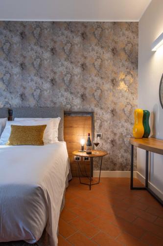 a bedroom with a bed and a table with a lamp at Braida Wine Resort in Rocchetta Tanaro