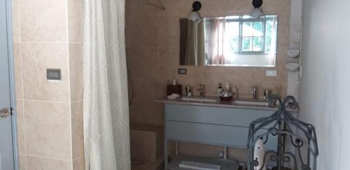 a bathroom with a sink and a shower with a mirror at SCHUMANN'S RESORT & PARK in Alto Boquete