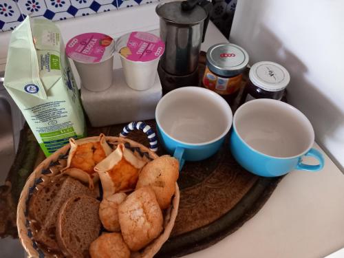 a plate of food and two cups on a counter at Casa Clery, stile toscano, vicino a firenze in Montelupo Fiorentino