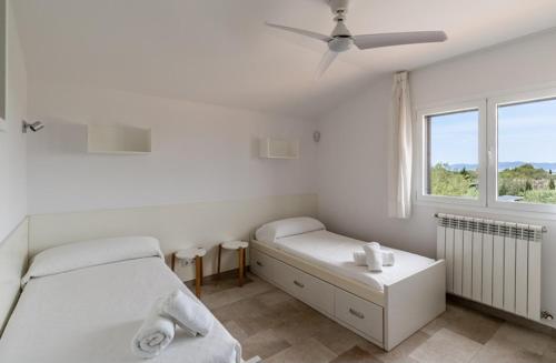 a bedroom with two beds and a window at Villa Can Bellmunt in La Aranjasa