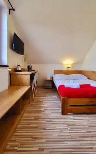 a hotel room with a bed and a desk at Gościniec Konopielka in Zblewo