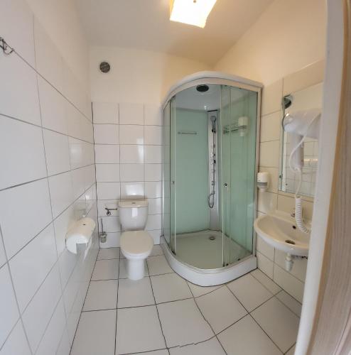 a bathroom with a shower and a toilet and a sink at Gościniec Konopielka in Zblewo