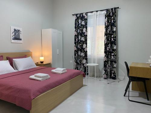 a bedroom with a bed and a desk and a window at Nasos Aegina Apartment in Aegina Town