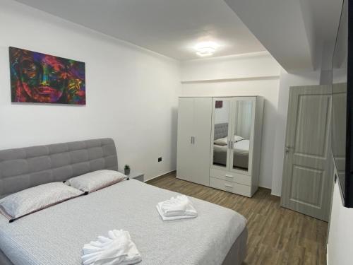 1 dormitorio con 1 cama y una pintura en la pared en Eric Apartment, en Mamaia Nord – Năvodari