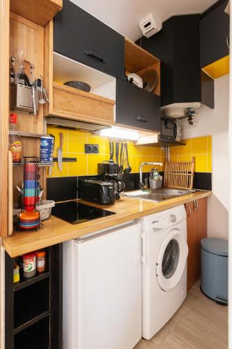 une petite cuisine avec lave-linge et sèche-linge dans l'établissement Le Bihan - Wifi - centre ville, à Vannes