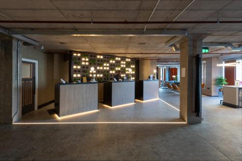 a lobby with a bar with lights on the wall at Sandman Signature Glasgow Hotel in Glasgow