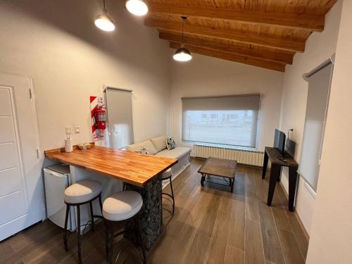 Zimmer mit einem Tisch und Stühlen sowie einem Wohnzimmer in der Unterkunft Moderno y tranquilo departamento in El Calafate