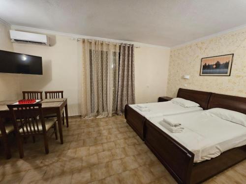 a hotel room with a bed and a dining table at Corfu Glyfada Beach Apartment in Glyfada